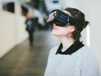 Une femme porte un casque de réalité virtuelle Head Mounted Display et regarde en l'air